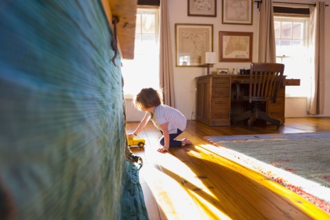 Caucasian boy on the floor playing with toy truck