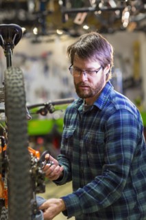 Caucasian man repairing bicycle in shop
