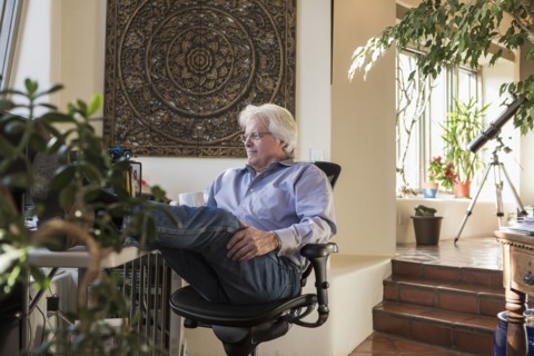 Caucasian man drinking coffee with feet up on desk