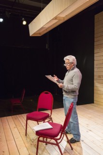Hispanic man reading script on theater stage