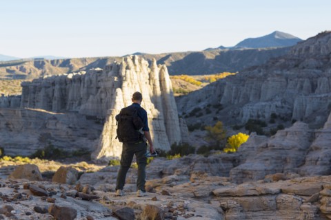 Caucasian man carrying backpack in desert