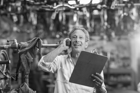 Caucasian man in bicycle shop talking on telephone