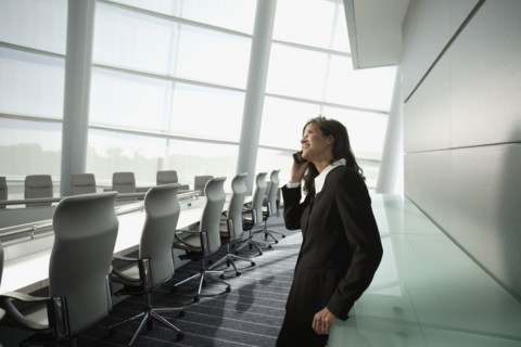 Businesswoman talking on cell phone in conference room