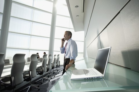 Businessman talking on cell phone in conference room