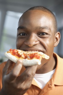 Close up of African man eating pizza