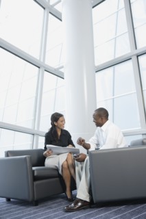 Businessman and businesswoman talking in office lobby