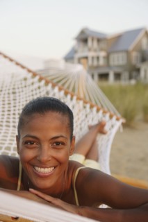 African woman laying in hammock at beach