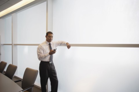 Hispanic businessman looking at electronic organizer