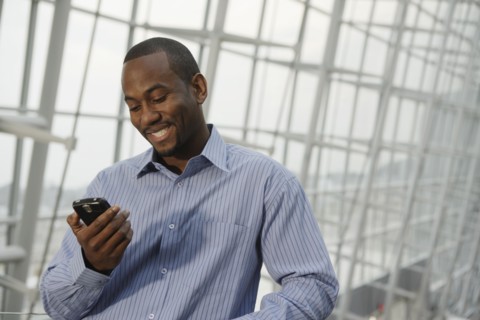 African American businessman looking at cell phone
