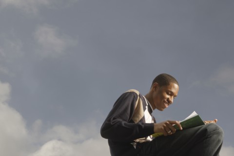 African man reading outdoors