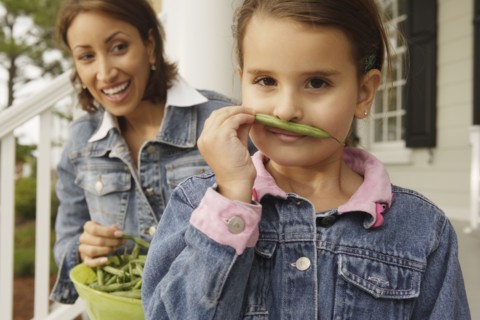 Hispanic mother and daughter with fresh green beans