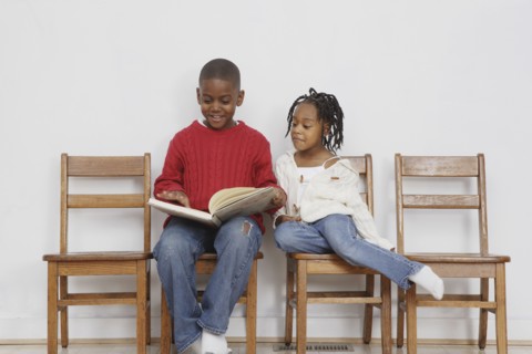 African boy reading to sister