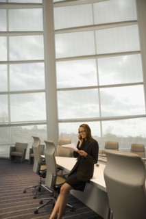 African businesswoman talking on cell phone in conference room