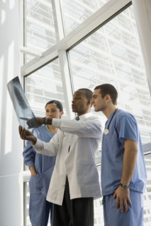 Multi-ethnic doctor and nurses reviewing x-ray by window