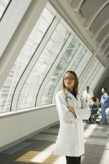 African doctor with arms crossed looking pensive in corridor