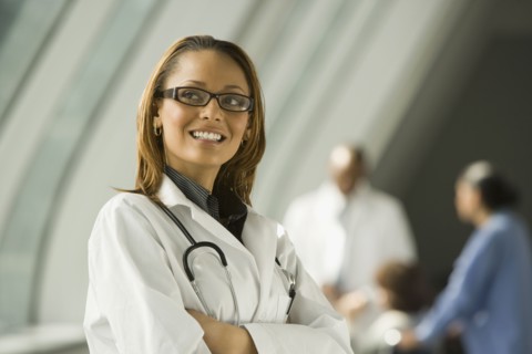 African doctor with arms crossed smiling