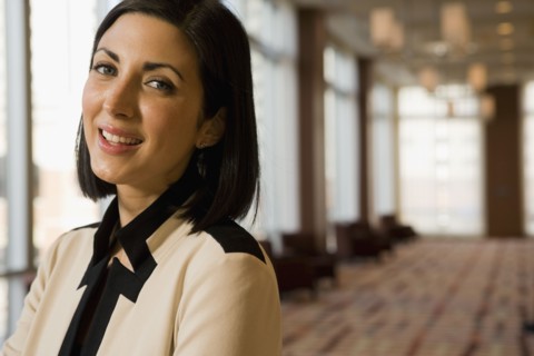 Close up of mixed race businesswoman smiling in corridor