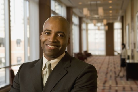 African businessman smiling in hotel corridor