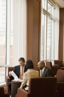 Multi-ethnic business people reviewing paperwork in lobby