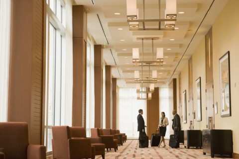 Multi-ethnic business people with suitcases in hotel