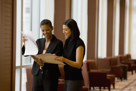 Multi-ethnic businesswoman reviewing paperwork in lobby
