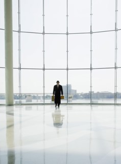 Hispanic man holding luggage in airport