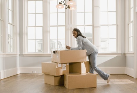 African woman using laptop on boxes