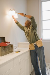African man repairing light fixture