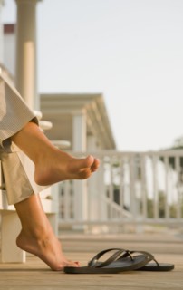 Mixed race woman barefoot near flipflops