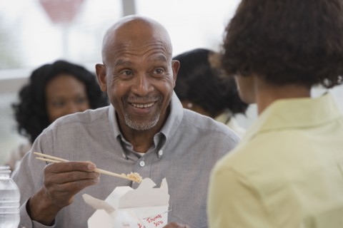 African man eating with chopsticks