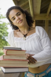 Hispanic woman standing with textbooks