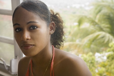 Hispanic woman sitting near window