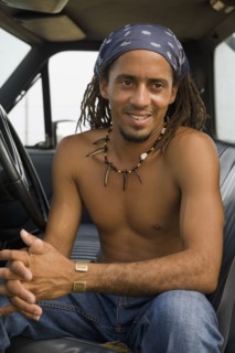 Bare chested Hispanic man sitting in cab of truck