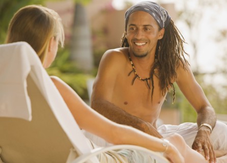Hispanic man sitting on lounge chair talking to girlfriend
