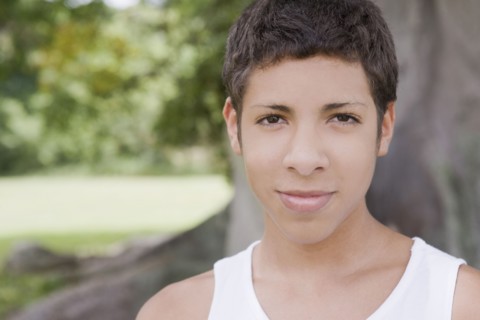Smiling Hispanic teenage boy standing outdoors