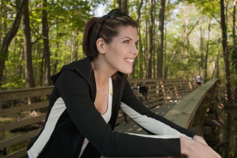 Mixed race woman leaning on bridge railing