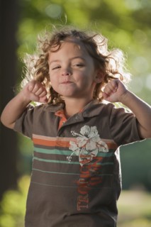 Mixed race girl grimacing with arms raised