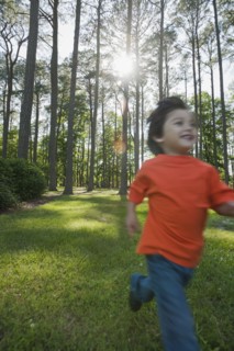 Hispanic boy running in forest