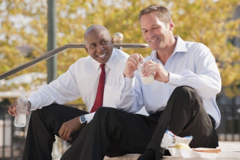 Businessmen eating lunch on steps
