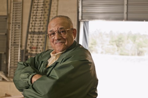 Mixed race man with arms crossed in warehouse