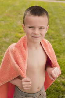 Caucasian boy wrapped in towel