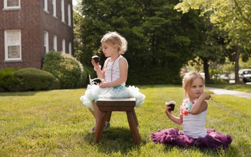 Caucasian girls playing dress up in yard