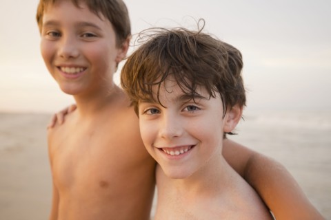 Caucasian boys walking on beach