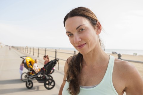 Caucasian woman smiling on beach boardwalk