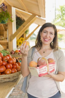 Hispanic woman holding produce at farmers market