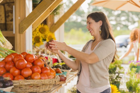 Hispanic woman browsing fruit at farmers market
