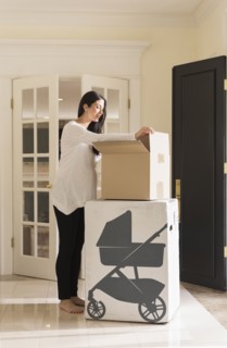 Pregnant Caucasian woman unpacking baby supplies