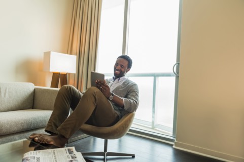Black man using digital tablet in living room