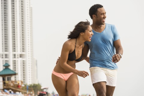 Couple laughing and walking on beach