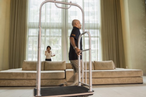 Bellhop pulling cart in hotel lobby